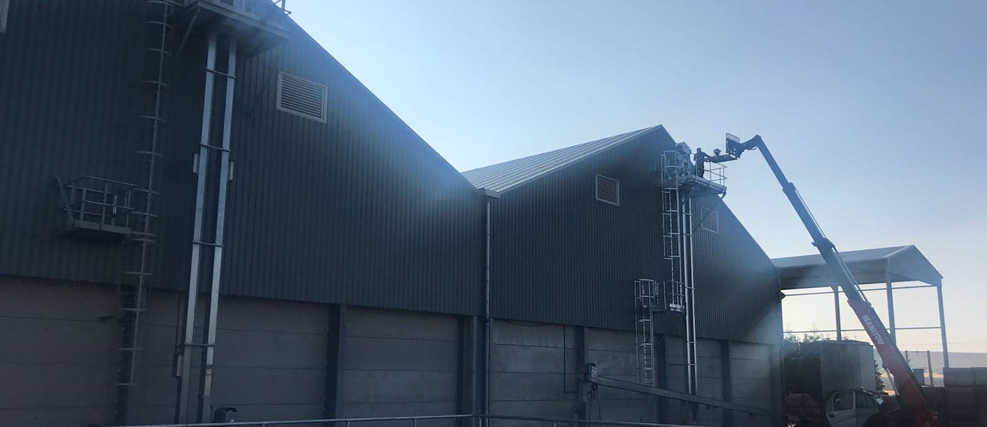 Access ladders, cherry picker and person working at The Bent Farm